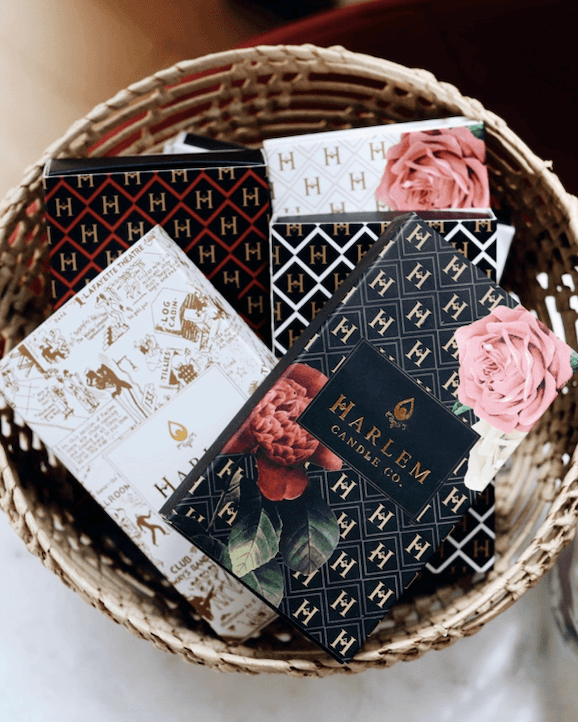 The lifestyle image shows a group of the Harlem Candle Co match boxes displayed in a decorative fashion.